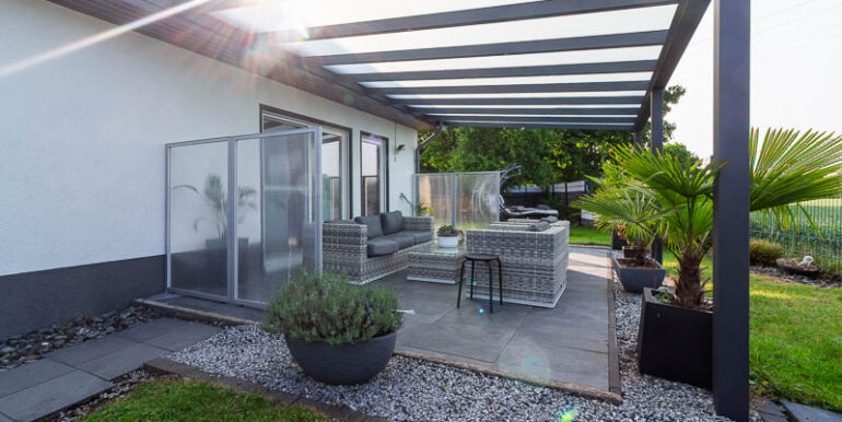 Stilvoller Outdoorbereich mit Glasüberdachung – ein Ort für gesellige Abende und ruhige Momente.
