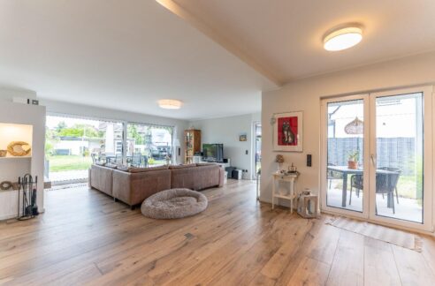 Wohnbereich mit Kamin und mehreren Zugängen zum liebevoll angelegten Garten